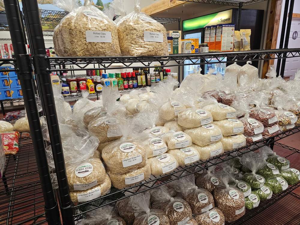 Shelves of bulk rice, beans and split peas bagged and labelled with The Elmira Store's own train logo.